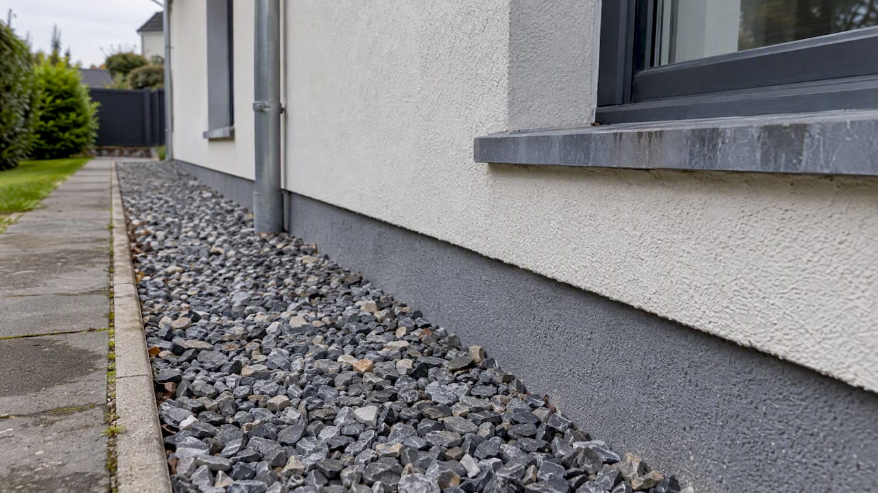 Ardoises et gravier au pied d’une façade
